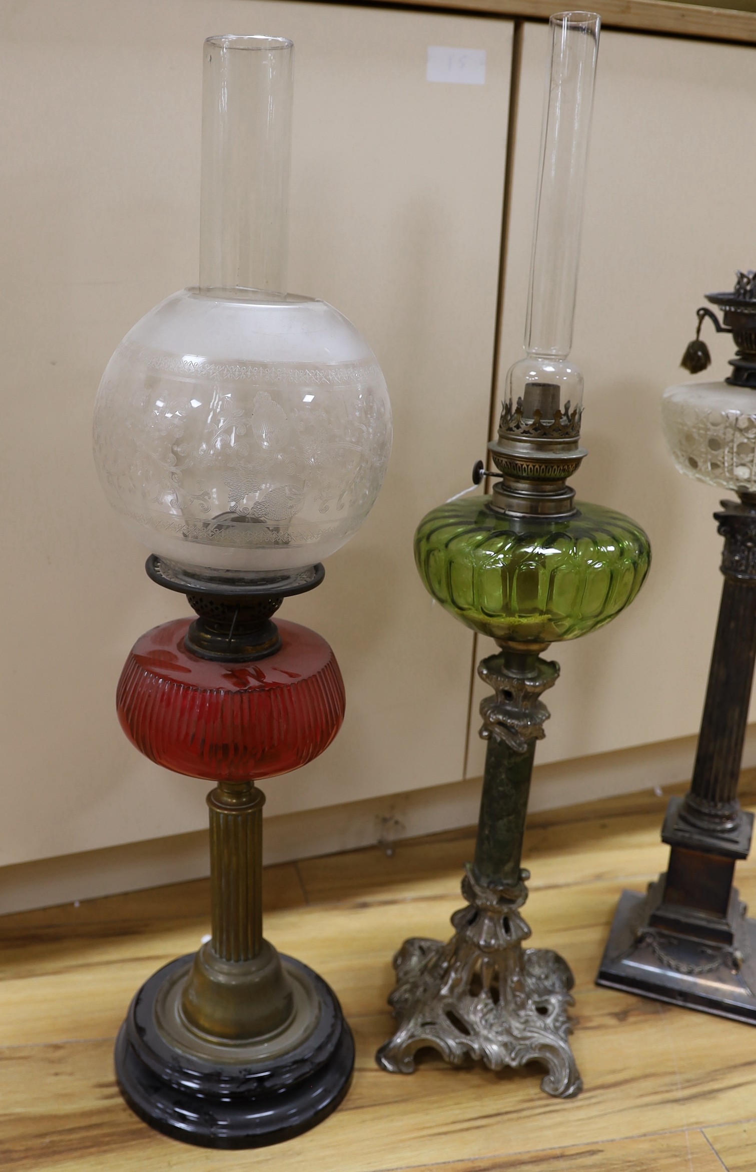 A Victorian plated oil lamp with glass reservoir, together with two others